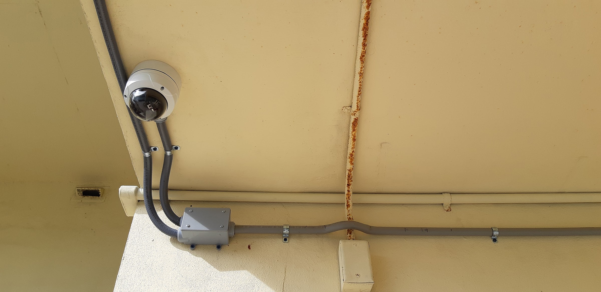 Dome camera with conduit under a soffit